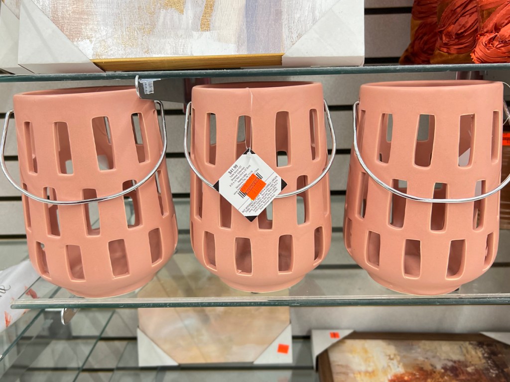 pink candle holders with handles on shelf