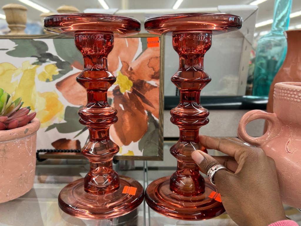 hand reaching for red candle holders