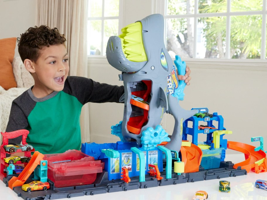 child playing with shark toy