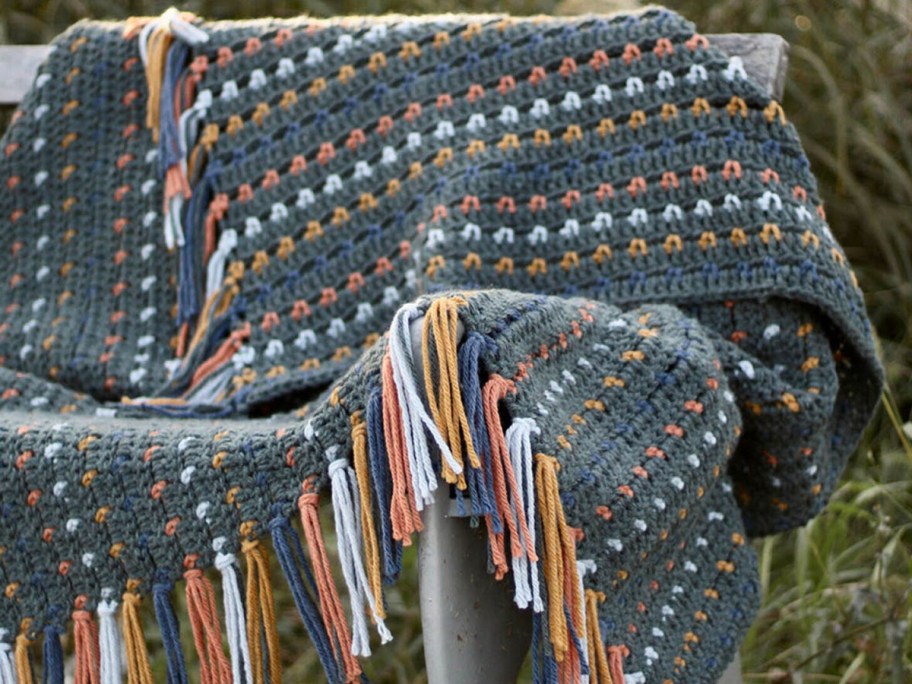 crochet blankey displayed on an arm chair