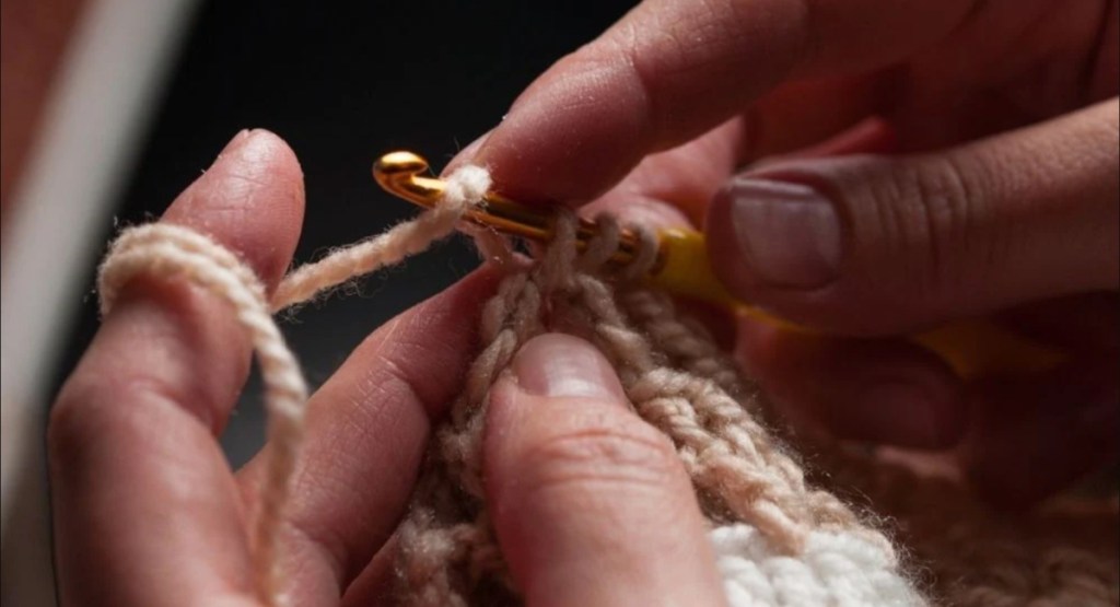 hands holding crochet needle