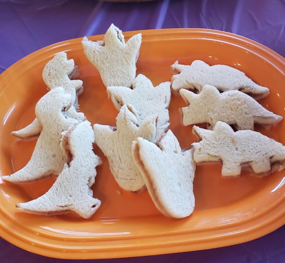 dinosaur shaped sandwiches on orange plate