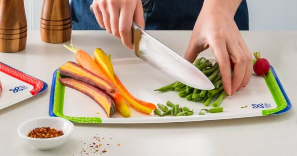 a woman chopping green beans on a dixie disposable cutting boards veg prep