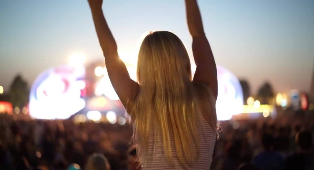 woman with hands in air at concert