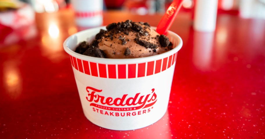 ice cream with oreo topping in freddys cup on red table
