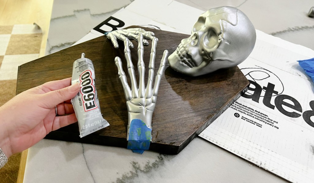 gluing painted skeleton hands to cutting board