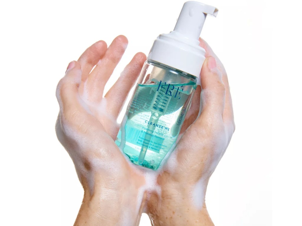 hands holding facial cleanser