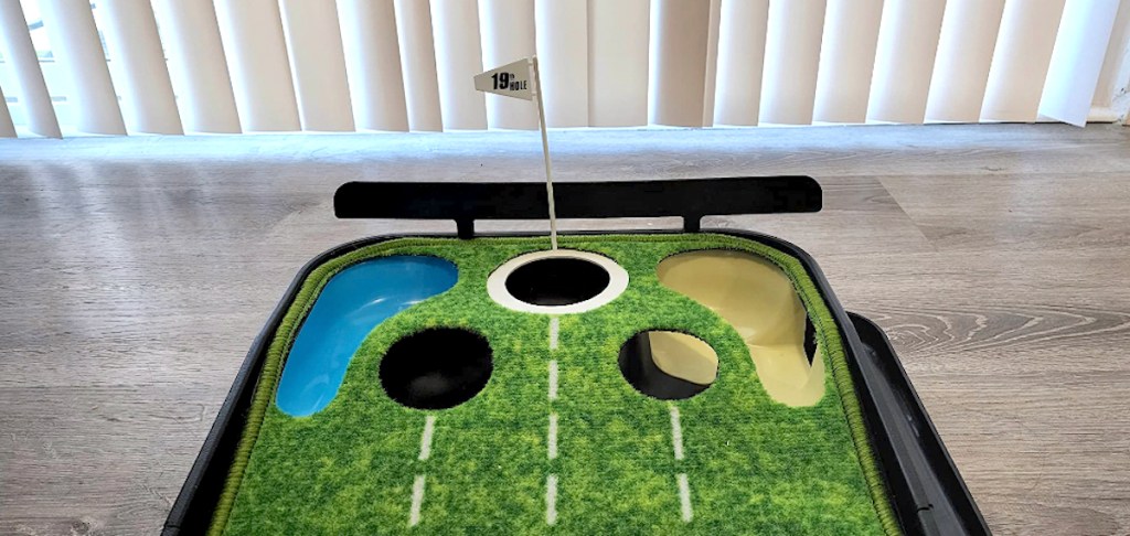 close up of top of indoor putting green with golf ball holes