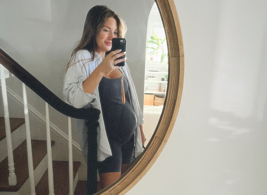 woman taking selfie in mirror wearing unitard