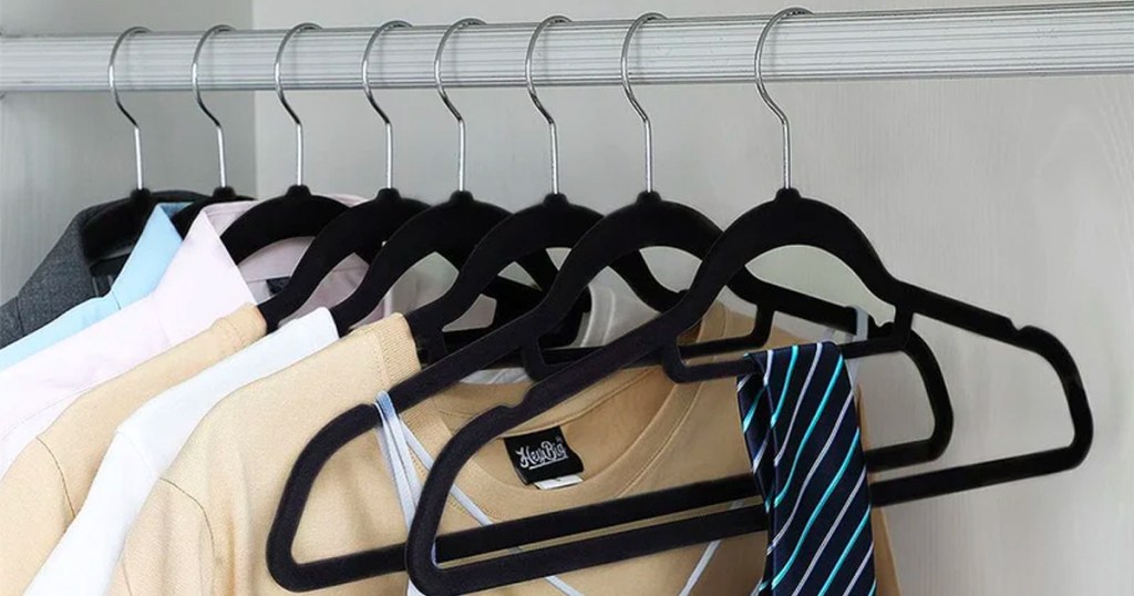 black velvet hangers in closet with clothes hanging on them