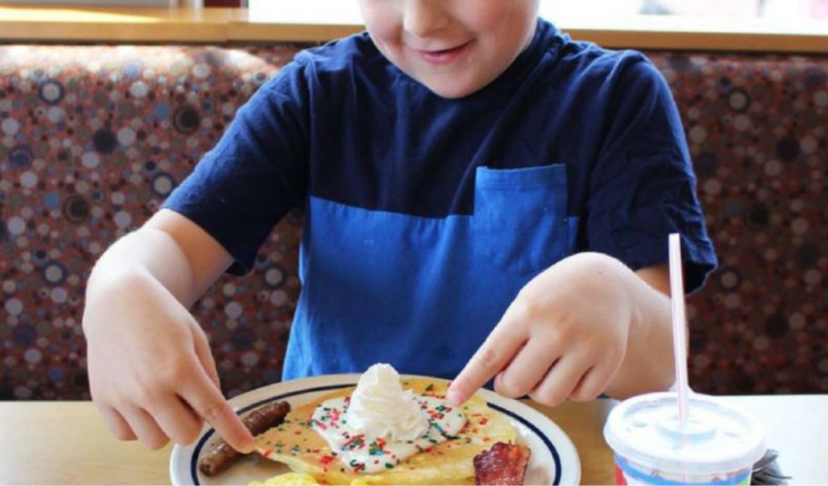 a little boy eating a kids meal at ihop