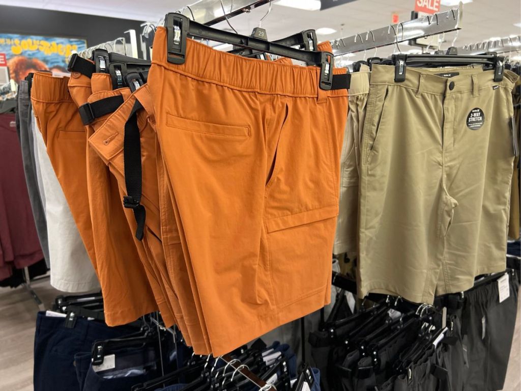 mens orange and tan shorts hanging in store