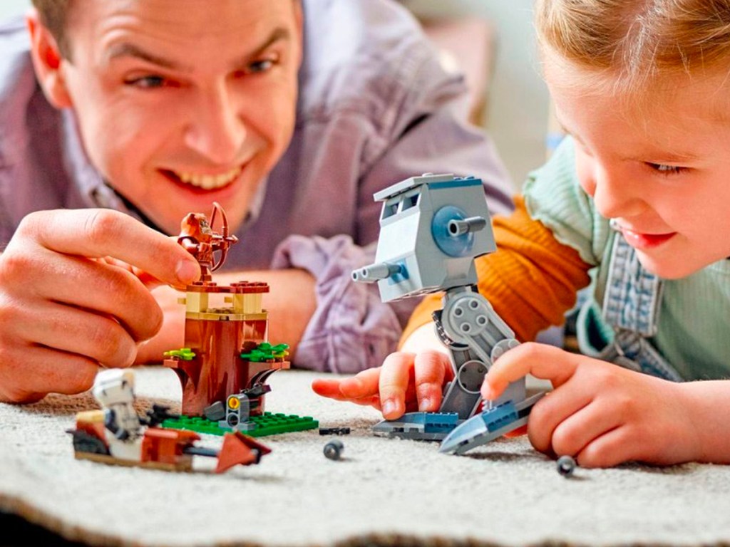 dad and child playing with lego star wars at at set