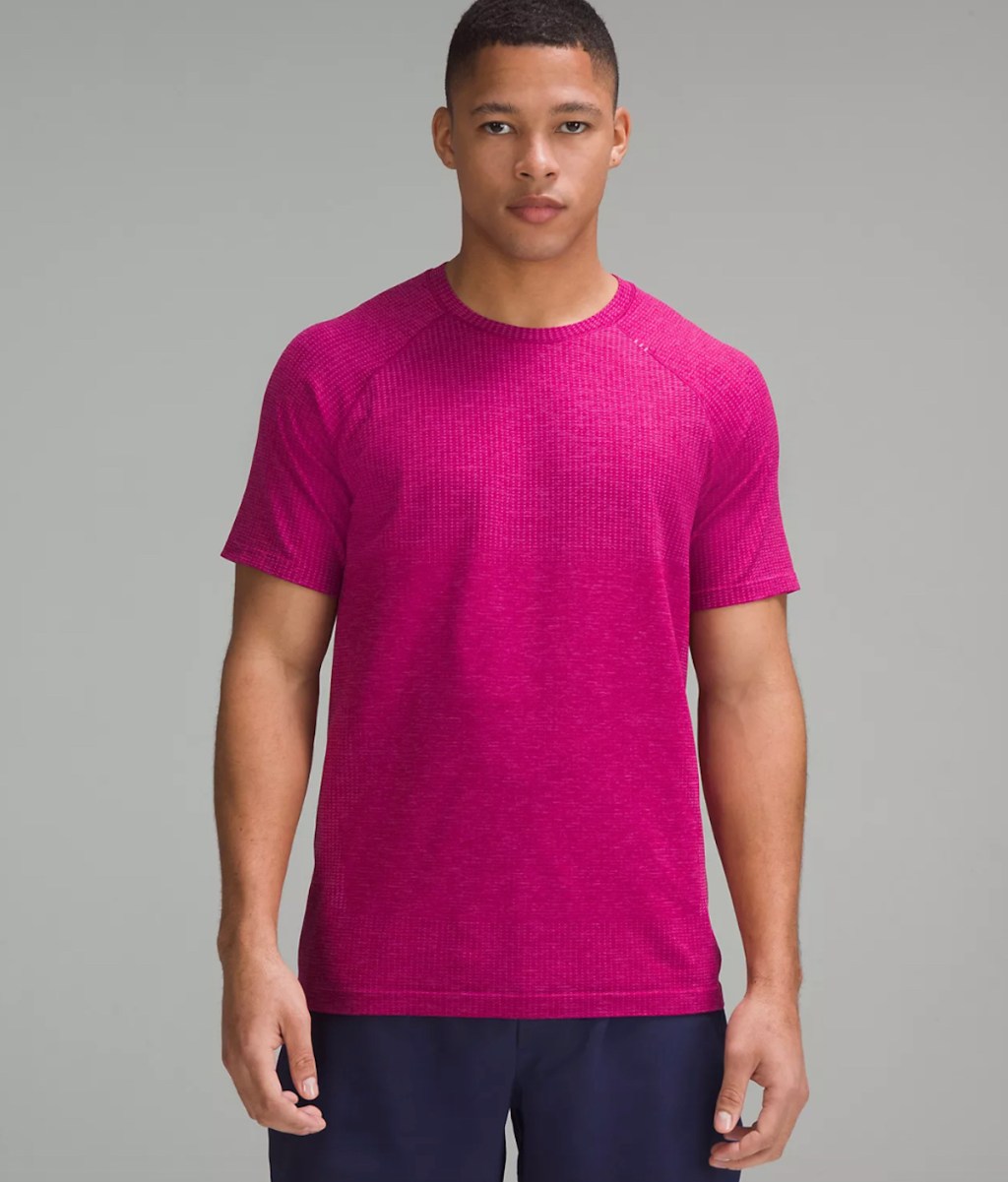 man wearing hot pink shirt with gray background