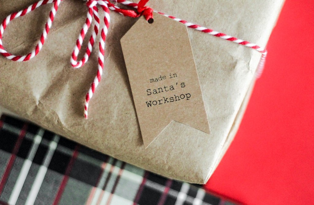kraft brown paper gift with holiday ribbon and santa gift tag