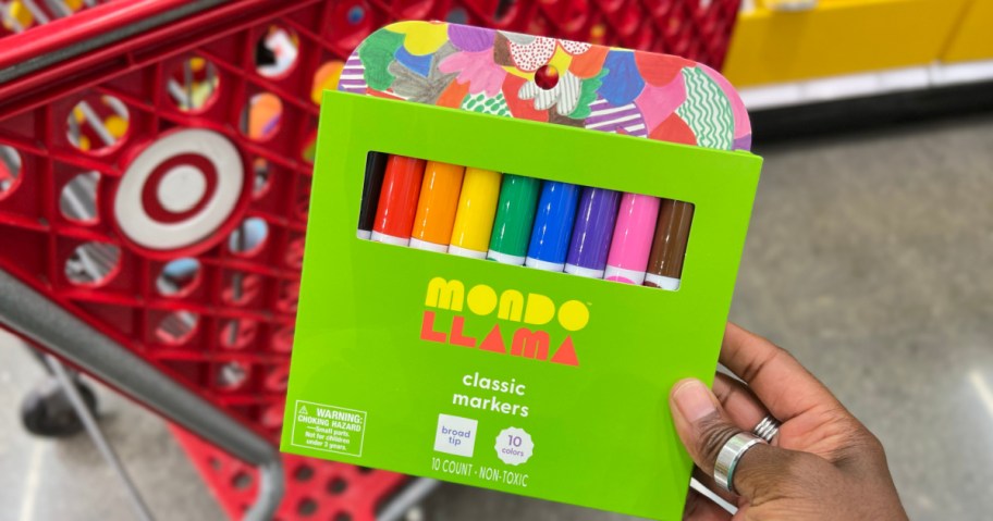 hand holding a pack of mondo llama colored markers in front of a target store cart