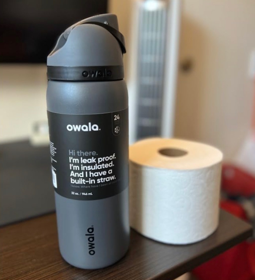 gray owala water bottle on table next to toilet paper