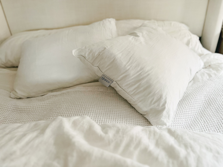 bare quince pillow on bed with white bedding and sheets