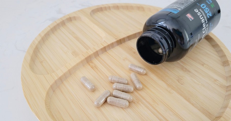 raw science vitamins bottle with vitamins laying on tray