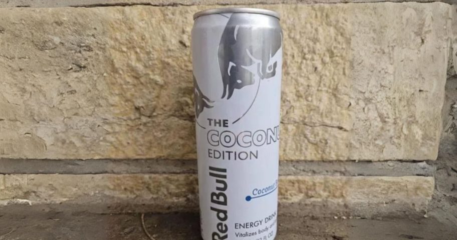 a single can of red bull coconut berry in front of a brick wall