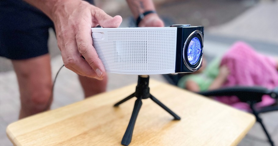 person sitting white projector down on table