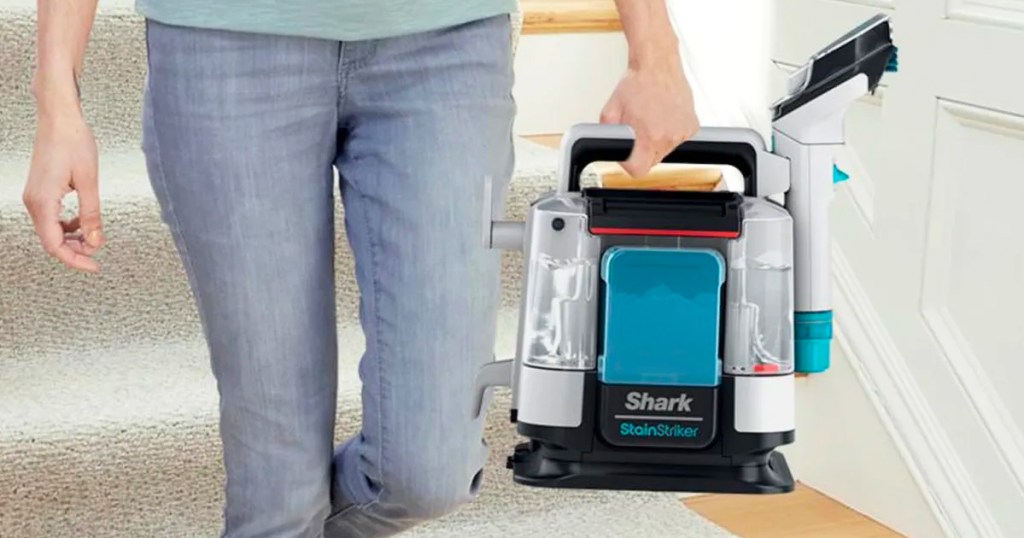 man holding shark stainstriker portable cleaner