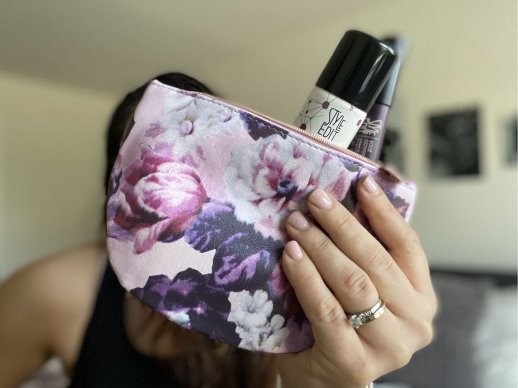 person holding cosmetic bag with Style Edit bottle sticking out