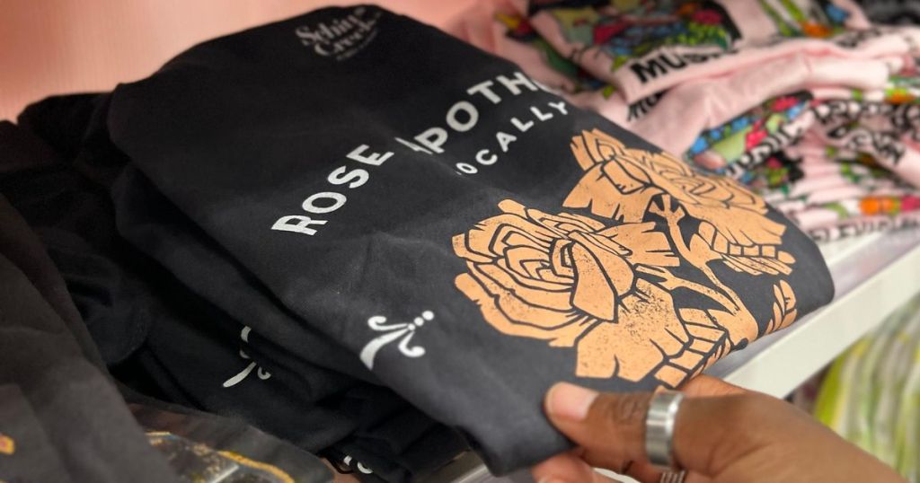 Hand touching a Rose Apothecary Tee at Target