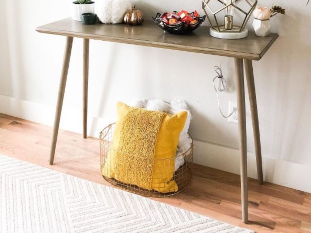 yellow square throw pillow in basket under entry table