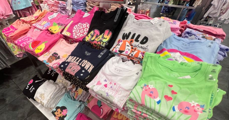 the children's place graphic tees folded on an in store display