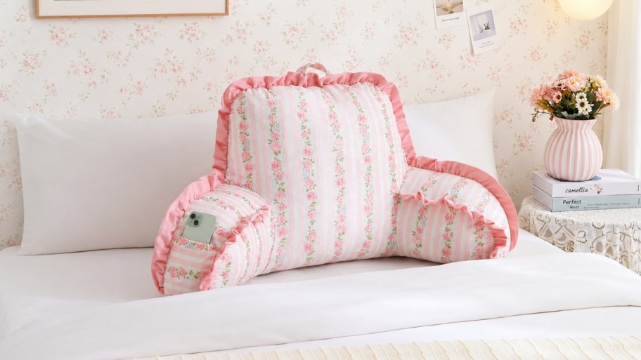 pink floral print backrest pillow on a bed