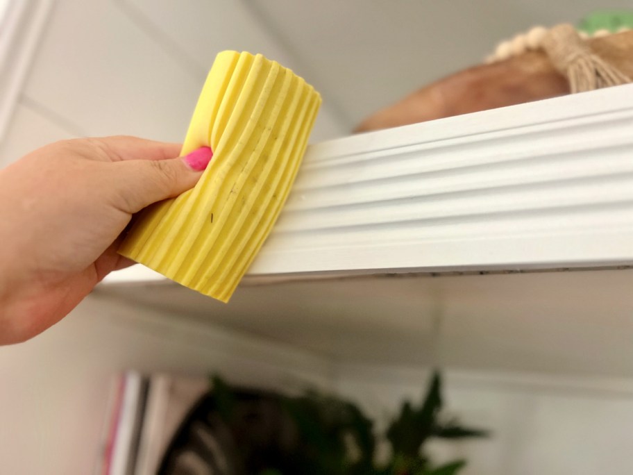 using a damp duster sponge on shelving