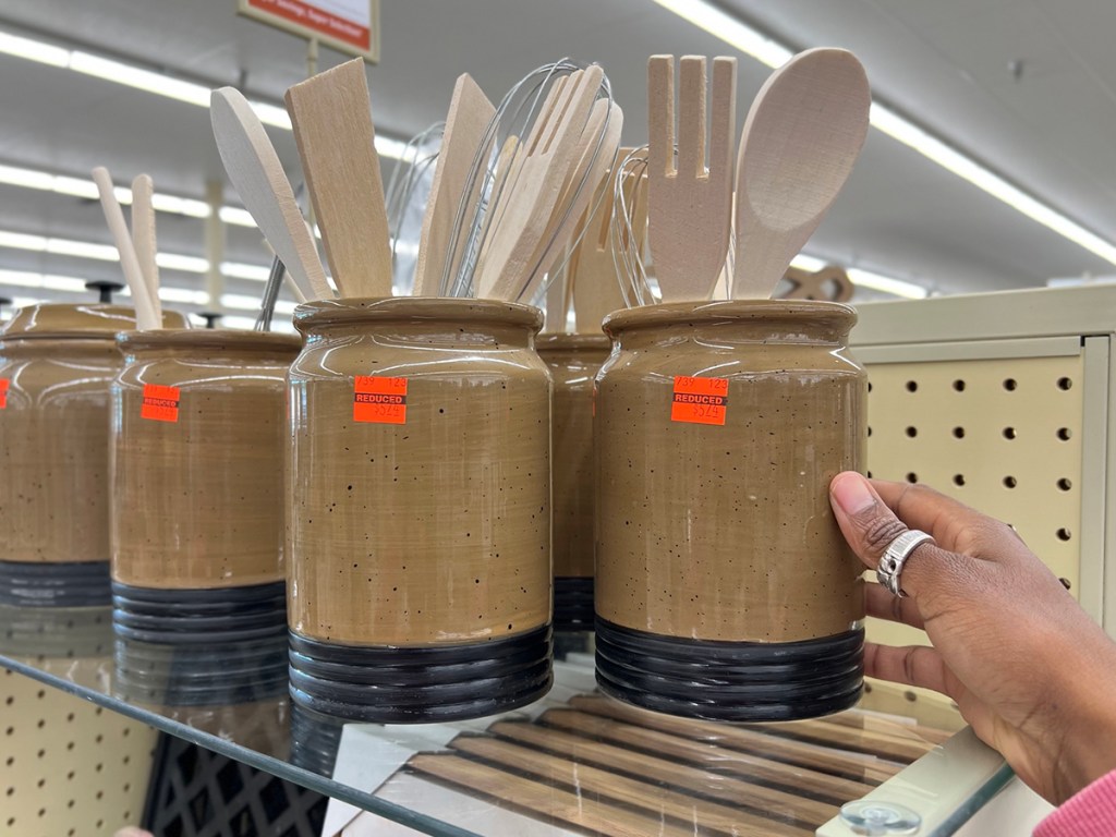 utensil jars with spoons and forks inside on shelf