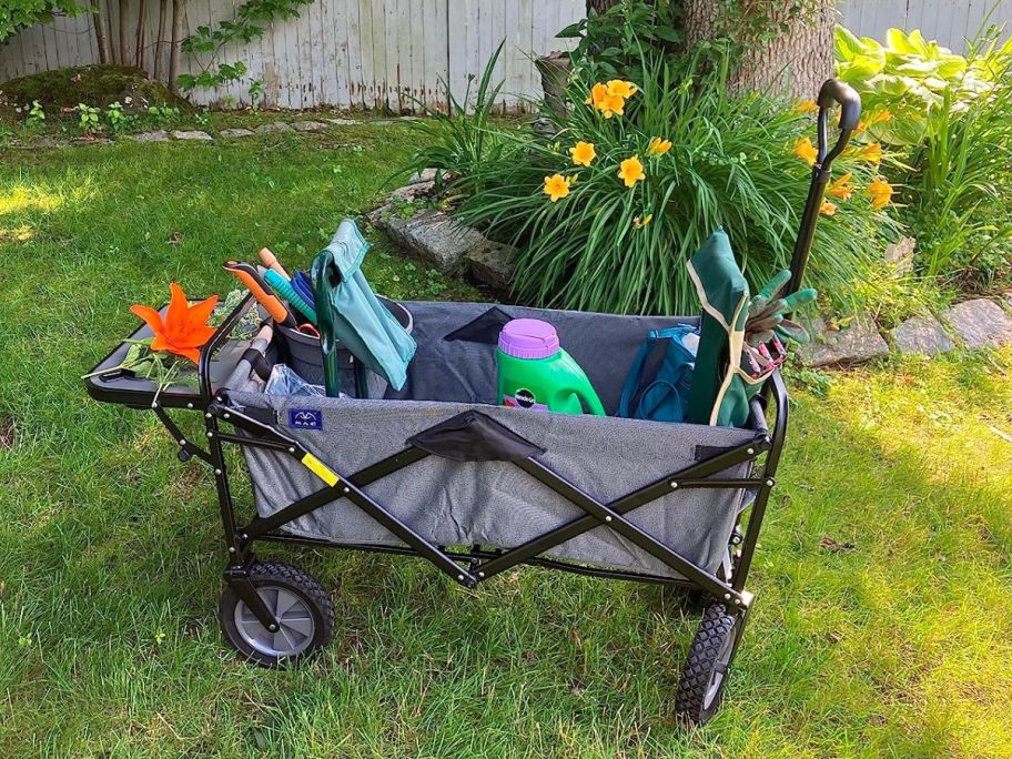 MacSports Collapsible Outdoor Utility Wagon with Folding Table and Drink Holders, Gray with gardening supplies in it
