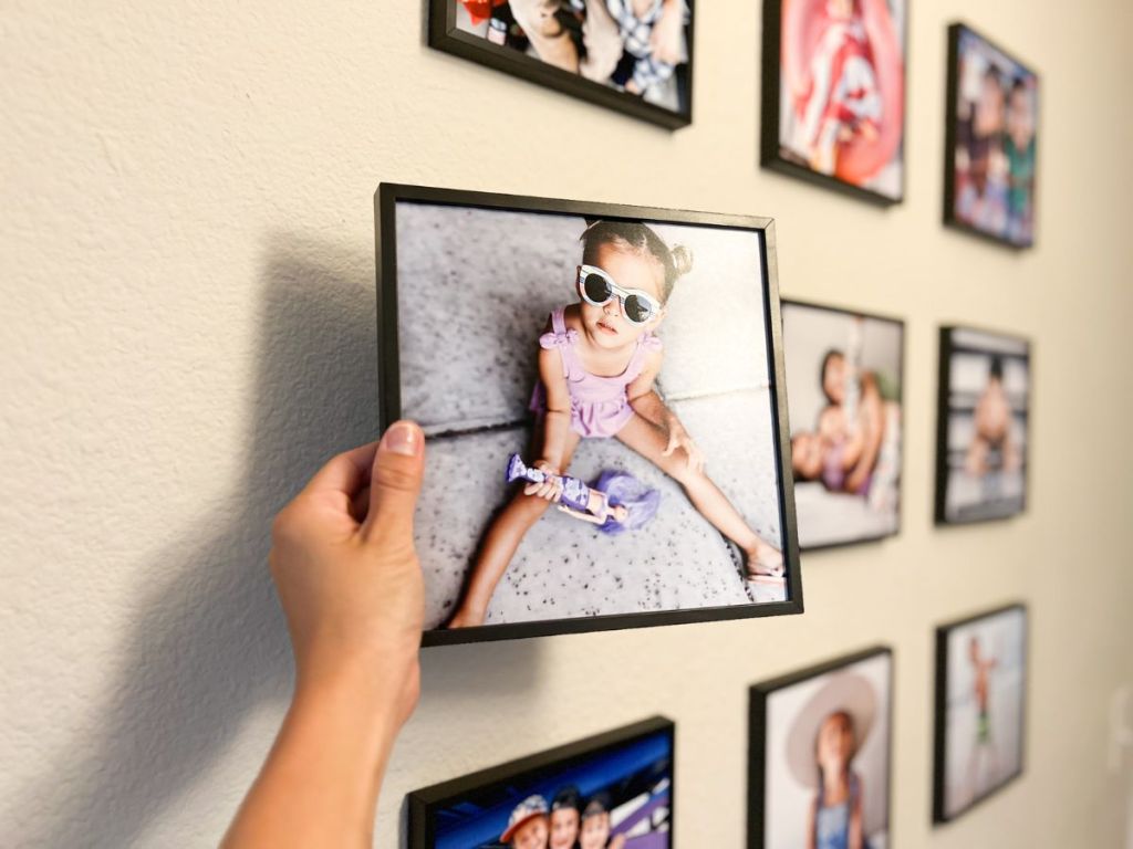 person putting up TilePix photo on wall