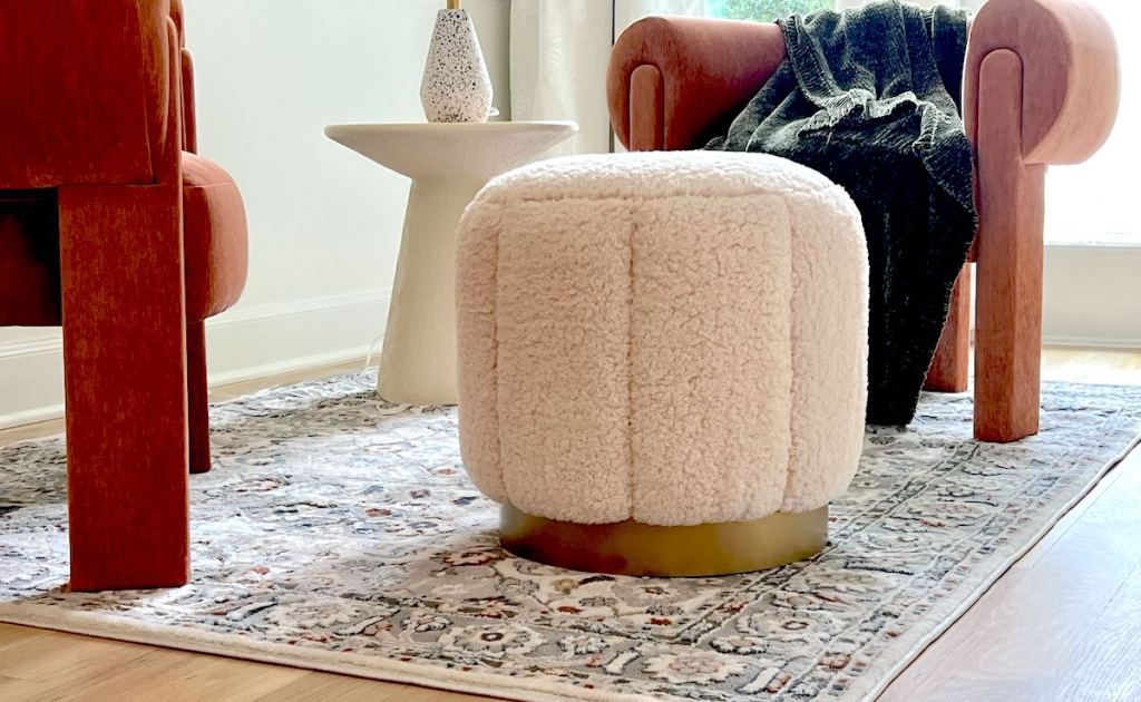 white sherpa ottoman on patterned rug with burnt orange modern chairs - things to buy at walmart
