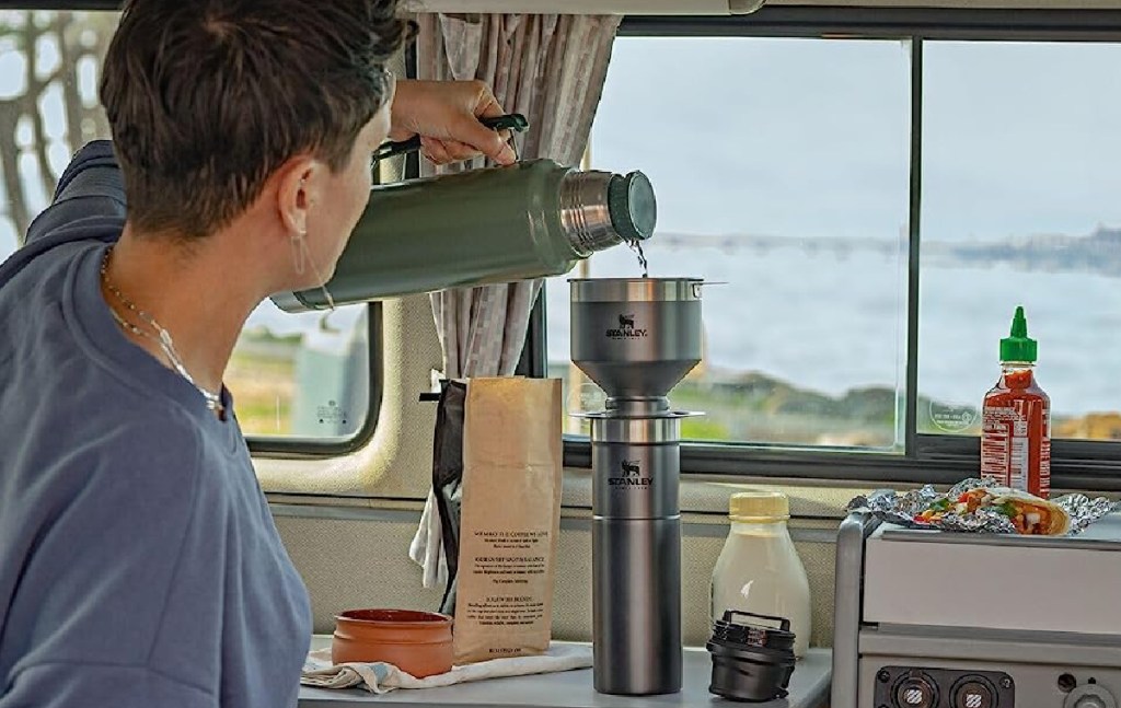 woman pouring drink into her stanley travel mug
