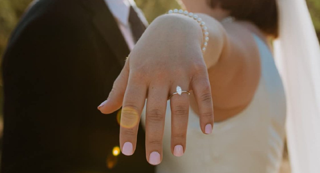 woman wearing press on nails with engagement ring