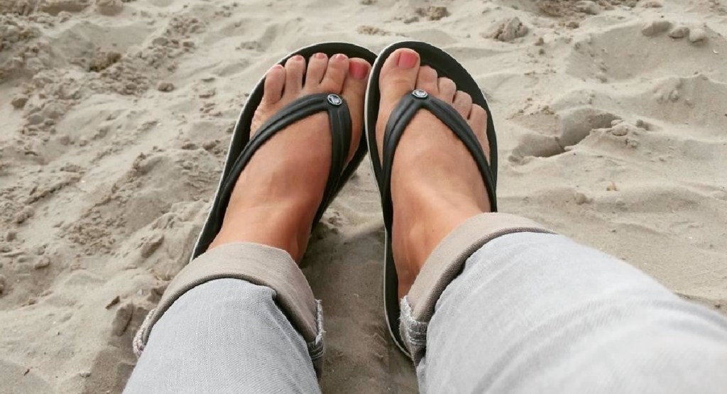 women's feet in crocs at the beach