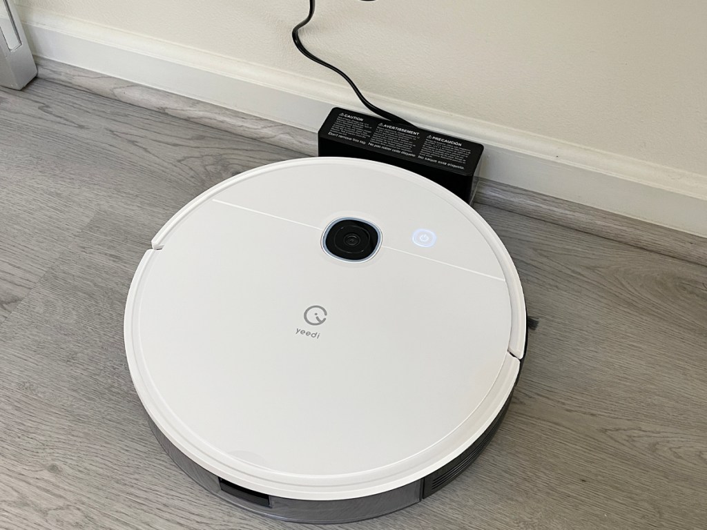 white yeedi robot vacuum on charger