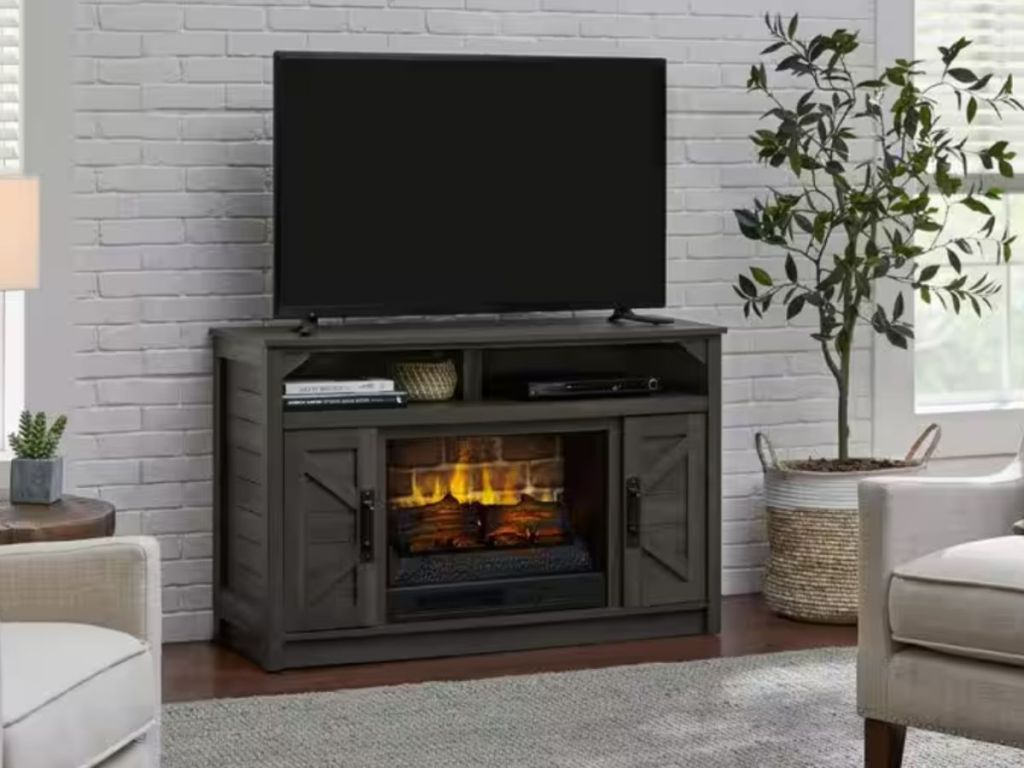 dark brown electric fireplace with TV on top in living room