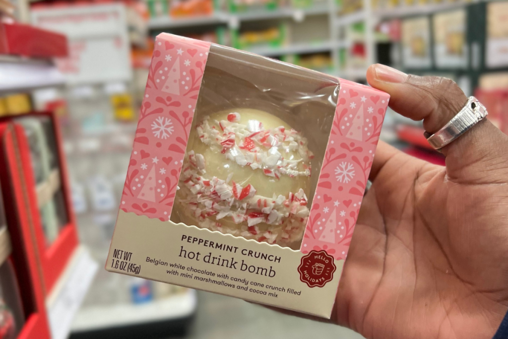 Hand holding a Peppermint Crunch Hot Cocoa Bomb in package at Target