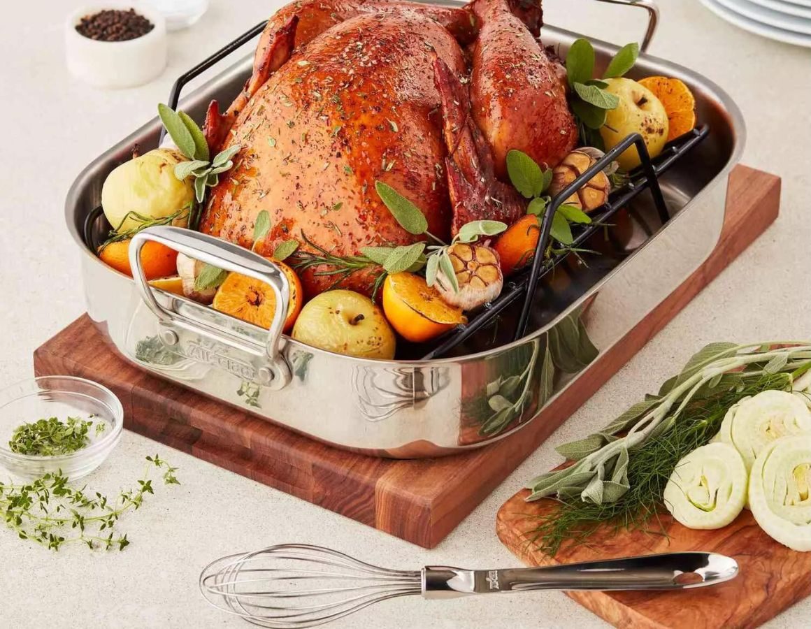 All Clad stainless roasting pan with a turkey in it
