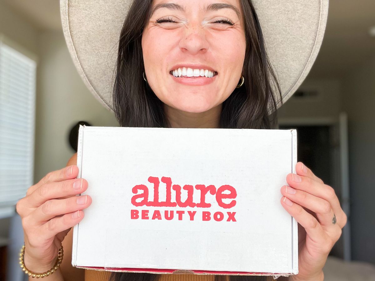 woman holding an Allure beauty box and smiling