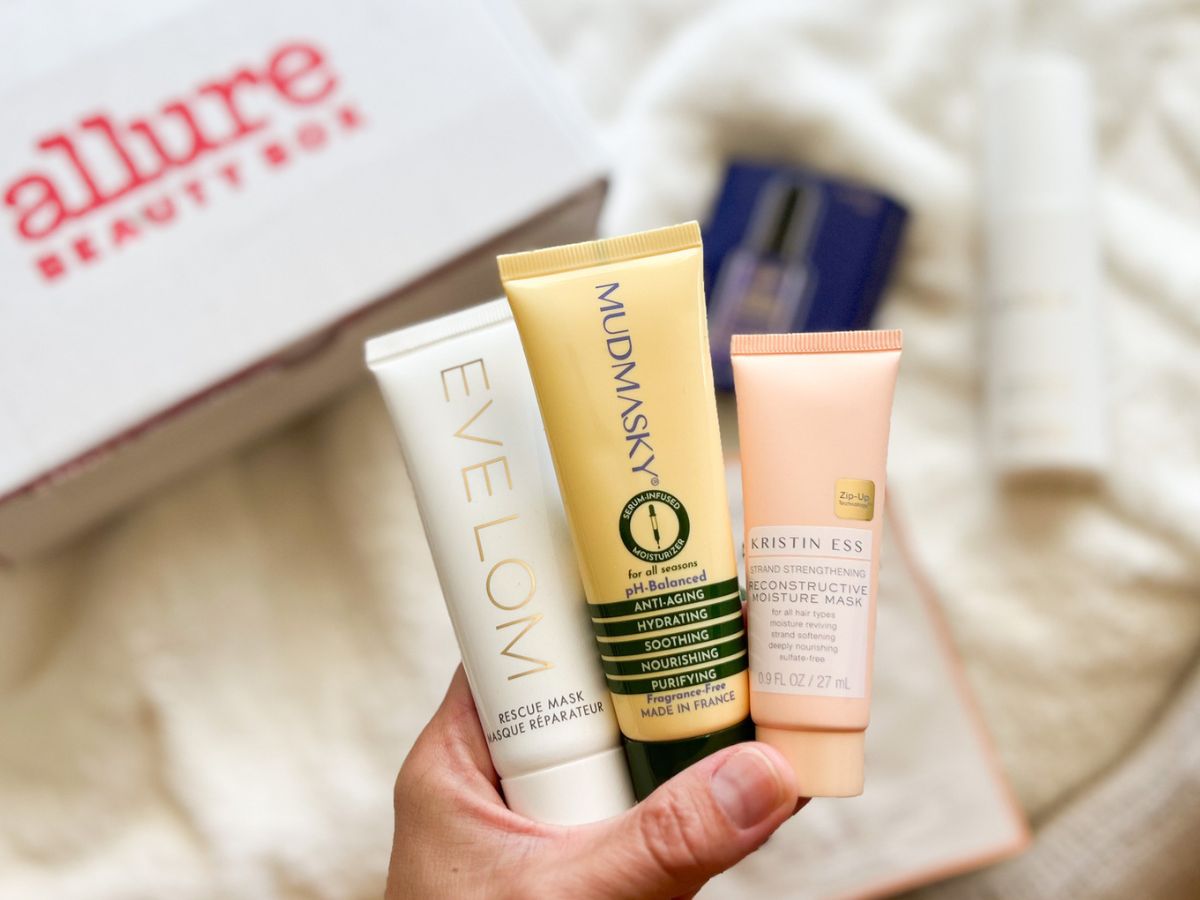 Hand holding 3 tubes of beauty products from the September 2023 Allure Beauty Box