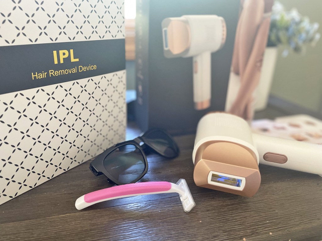ipl laser device, razor, and sunglasses on table