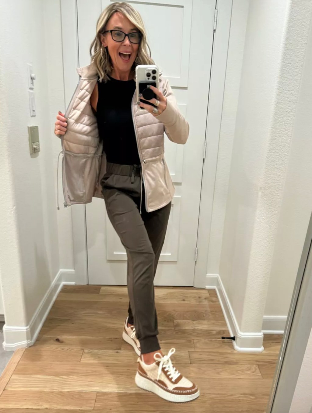 woman taking mirror selfie wearing athletic outfit