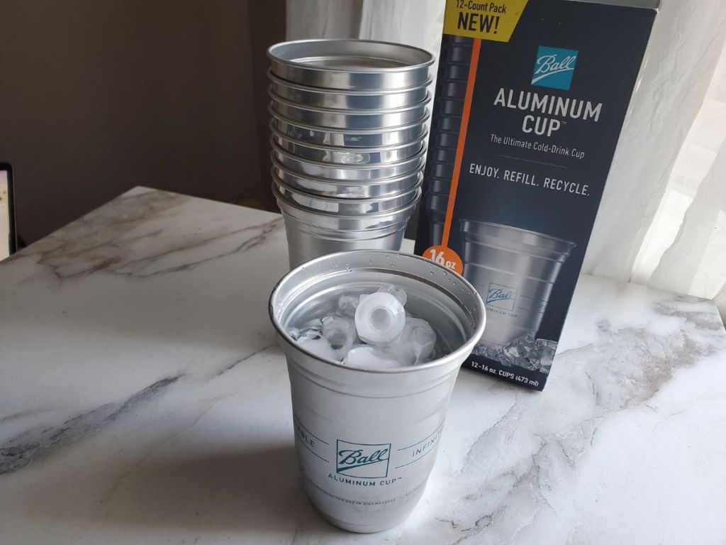 Ball Aluminum Reusable Cups stacked next to a box while one is filled with ice 