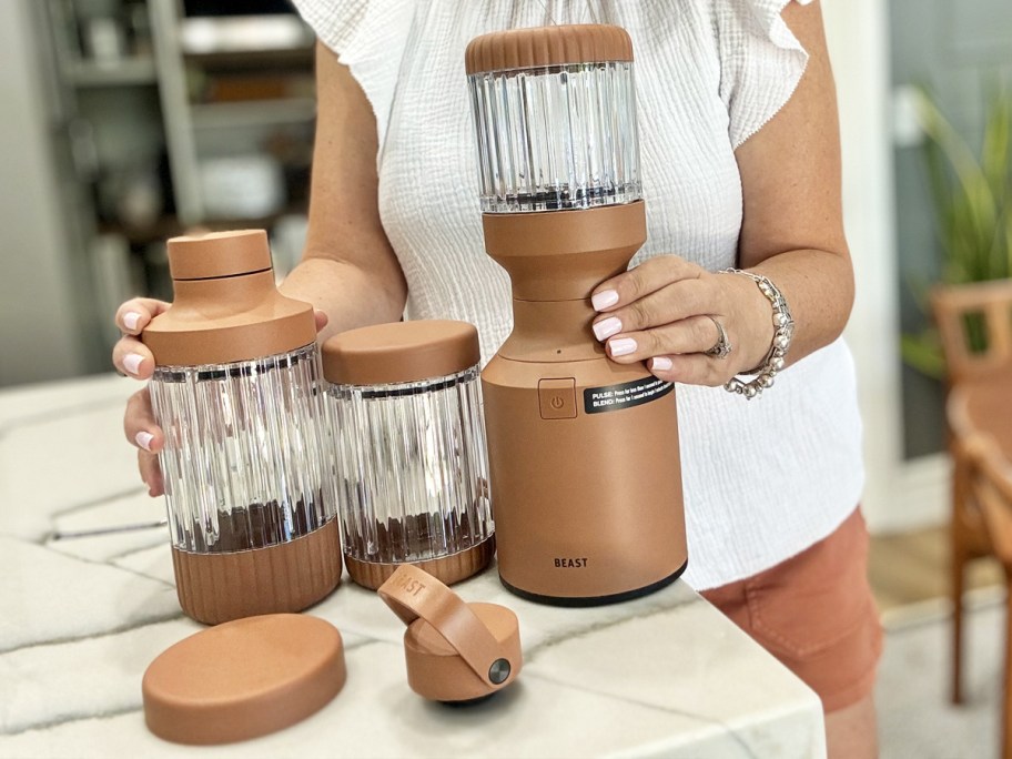 woman standing behind beast blender items on kitchen counter