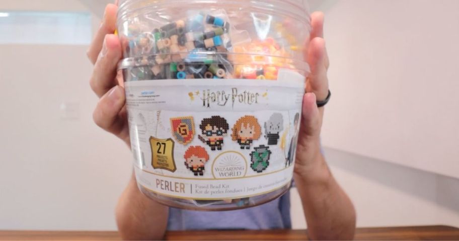 A man holding a Big Bucket Harry Potter Perler Fuse Bead Kit